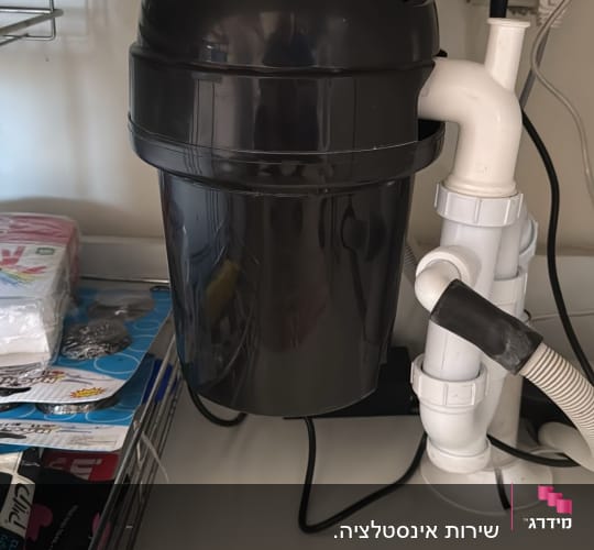 מטחנת אשפה מתחת לכיור עם צינורות חיבור